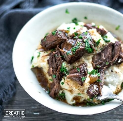 Balsamic Beef Pot Roast meat chunks in a bowl on top of cauliflower